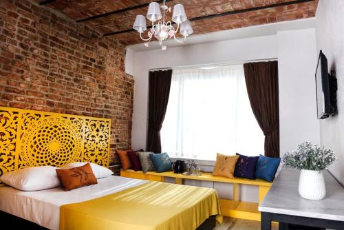 a bedroom with a yellow bed and a brick wall at AYSA Hotel in Istanbul