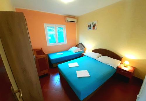 ein Hotelzimmer mit 2 Betten und blauer Bettwäsche in der Unterkunft Apartments Sonja in Kotor