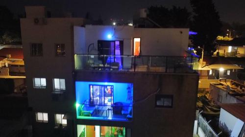 a view of a building at night with blue lights at comft suite Nahariyya in Nahariyya