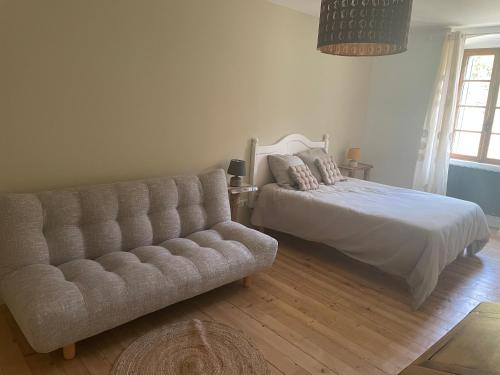 a bedroom with a bed and a couch at Du Vent Dans Les Arbres -120m2 Belle vue sur le lac in Chindrieux