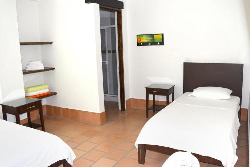 a room with two beds and two tables at Chrisban Hotel Boutique in Buga