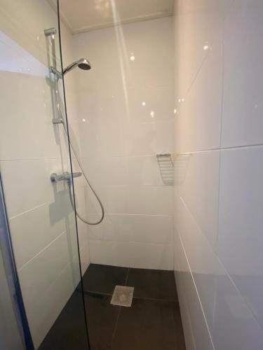 a bathroom with a shower with a glass door at Hotel 't Sonnehuys in Scheveningen