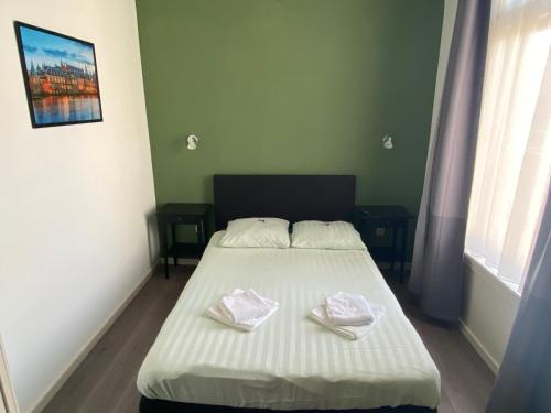 a bed in a room with two towels on it at Hotel 't Sonnehuys in Scheveningen