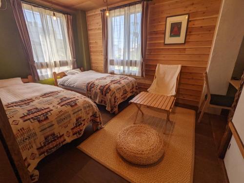 ein Zimmer mit 2 Betten und einem Stuhl darin in der Unterkunft Noasobi Lodge 201- Vacation STAY 45770v in Arao