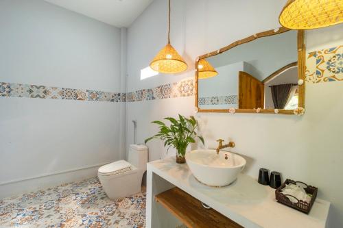 a bathroom with a sink and a toilet and a mirror at Khu Nghỉ Dưỡng Green Bungalow Phu Quoc in Phu Quoc