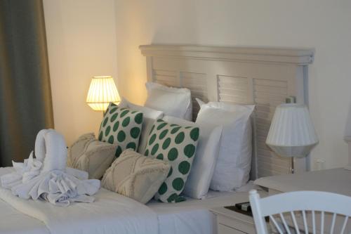 a bed with a bunch of pillows on it at Hotel Villa Maya in Saint-Tropez