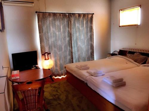 a room with two beds and a table and a window at Kumamoto Farm Stay 2F - Vacation STAY 12481 in Takemiya