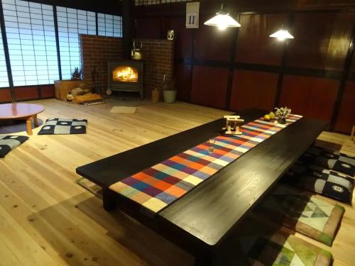 a living room with a table with a fireplace at Minshuku Otaki fireplace - Vacation STAY 46344v in Miyaki