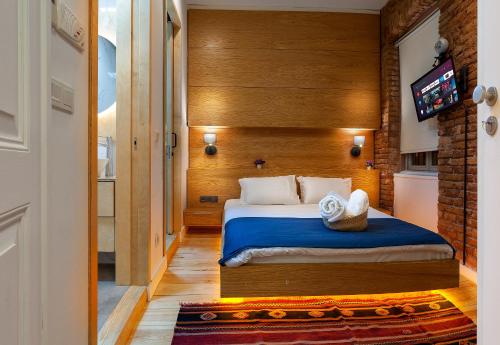 a bedroom with a bed and a tv on a wall at Kumbaracı Apartments & Suites in Istanbul