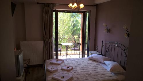 a bedroom with a bed and a door to a balcony at Guesthouse Kastania Korakis in Kastania