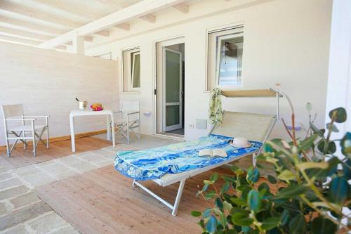 un letto su un patio con tavolo e sedie di Stabilimento Lido Burrone a Favignana