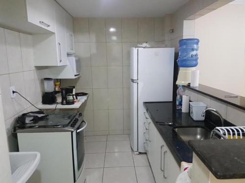 una piccola cucina con frigorifero e lavandino di Vila del mar prainha ad Arraial do Cabo