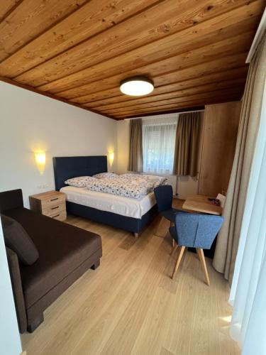 a bedroom with a bed and a couch and a table at Pension Sommerauer in Hallein