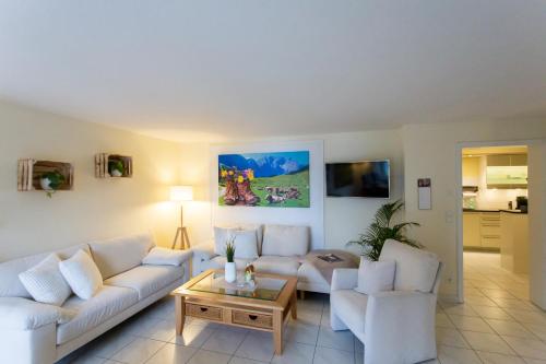 ein Wohnzimmer mit weißen Sofas und einem Couchtisch in der Unterkunft Eleganz - fantastischer Bergblick - absolute Ruhe in Hagspiel