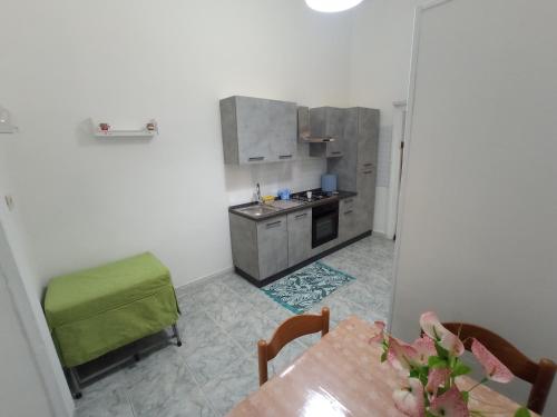 una piccola cucina con tavolo e sedia verde di Flegrei Apartment a Napoli