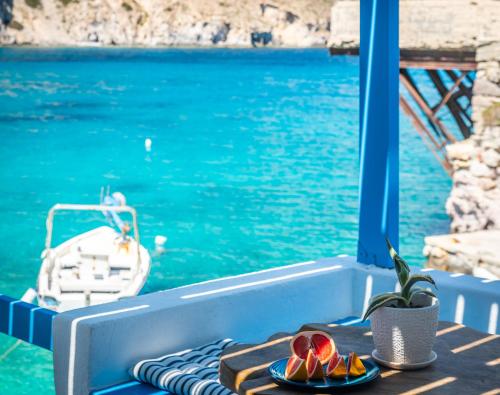 un tavolo con piatti di frutta in cima a una barca di Aquanis Anchored, sea front house, Firopotamos a Firopótamos