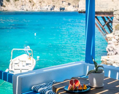 a table with plates of fruit on top of a boat at Aquanis Anchored, sea front house, Firopotamos in Firopótamos