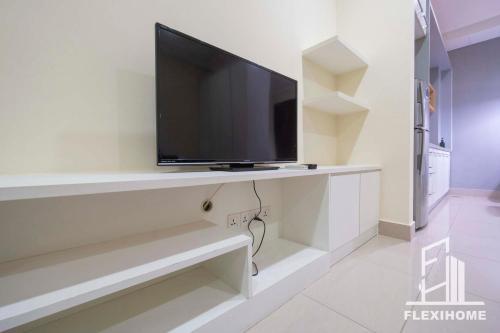 a flat screen tv on a wall in a living room at 9am-5pm, SAME DAY CHECK IN AND CHECK OUT, Work From Home, Shaftsbury-Cyberjaya, Comfy Home by Flexihome-MY in Cyberjaya