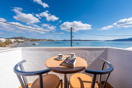 a table and chairs on a balcony with a view of the water at Milos Inn in Adamantas