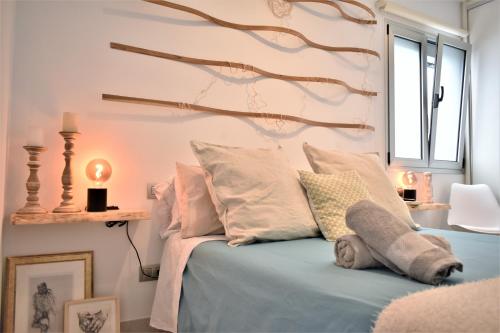um quarto com uma cama com um galho de árvore na parede em Viuter - Magna Home las Canteras Beach + Parking em Las Palmas de Gran Canaria