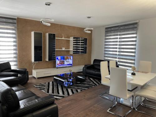 a living room with black leather furniture and a tv at Piso Moderno -Baia Mare in Baia Mare