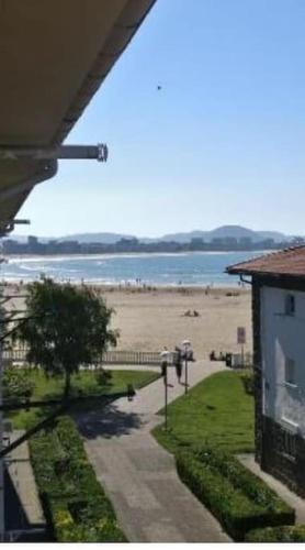 a view of a beach with a building and a house at Laredo primera línea de playa,zona puerto deportivo in Laredo