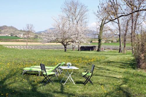 a table and two chairs in a field with trees at Touroulet in Suze