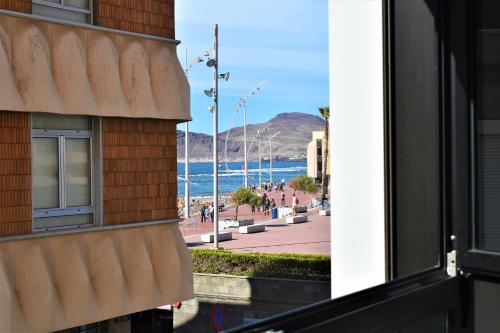 uma janela de um edifício com vista para o oceano em Viuter - Magna Home las Canteras Beach + Parking em Las Palmas de Gran Canaria