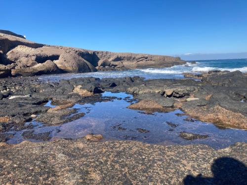 a pool of water on the rocks at the beach at Casa Dora: Tradicional y al borde del mar. in Poris de Abona