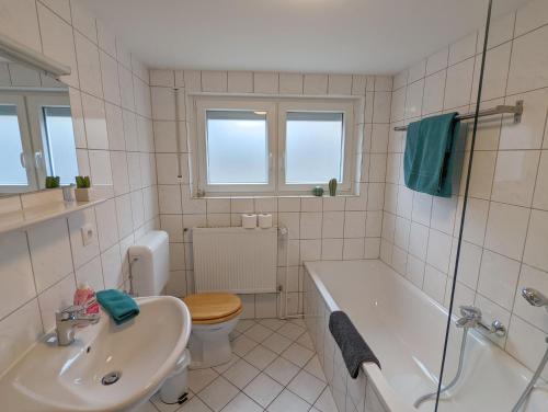 ein Badezimmer mit einer Badewanne, einem WC und einem Waschbecken in der Unterkunft Abendsonne Apartments in Koblenz