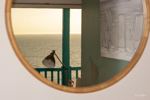 a mirror reflecting a room with a view of the ocean at Le COURLIS vue panoramique sur la mer, balcons in Ault