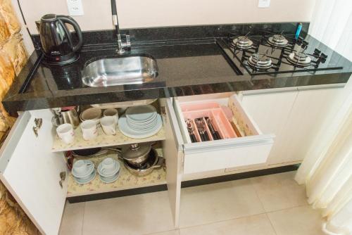 Una encimera de cocina con un fregadero y una estufa. en Suites da Lu, en Penha