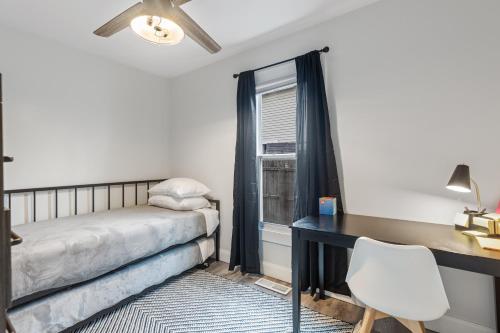 a bedroom with a bed and a desk and a window at SUPERB 3 Bedroom Home with Game Room!!! Close to Downtown - Sleeps 6 in Lansing