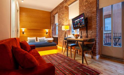 a hotel room with a bed and a table and a couch at Kumbaracı Apartments & Suites in Istanbul