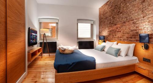 a bedroom with a large bed and a brick wall at Kumbaracı Apartments & Suites in Istanbul