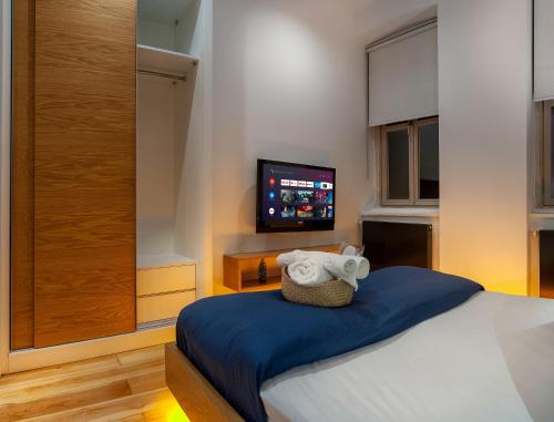 a bedroom with a bed with a tv on the wall at Kumbaracı Apartments & Suites in Istanbul