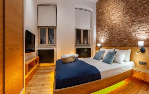 a bedroom with a bed and a brick wall at Kumbaracı Apartments & Suites in Istanbul