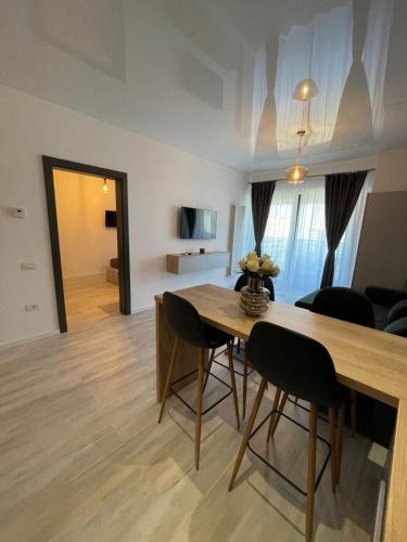 a dining room and living room with a table and chairs at Mirage Sea Breeze Apartment in Mamaia
