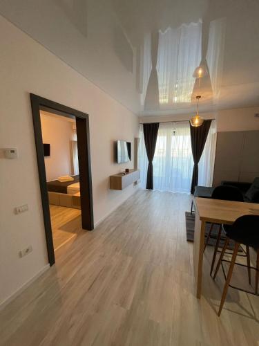 a living room with a table and a bedroom at Mirage Sea Breeze Apartment in Mamaia