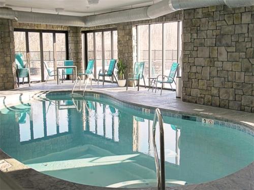 a swimming pool with blue chairs and tables in a building at The Wallhouse Hotel, an Ascend Collection Hotel in Walnut Creek