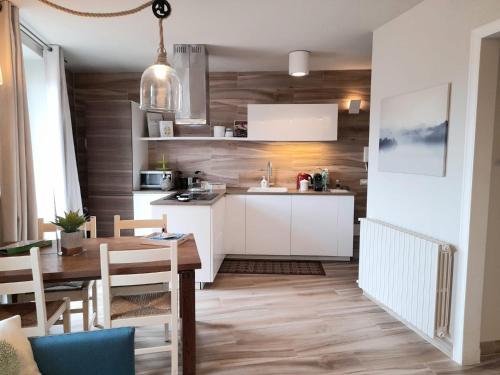 a kitchen with white cabinets and a wooden floor at Magnolia@27 Lake Iseo in Sarnico