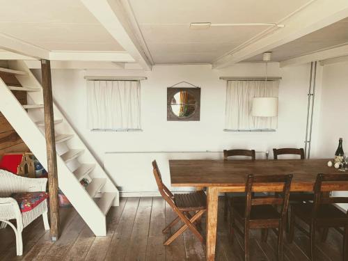 a dining room with a wooden table and chairs at Authentic Farmhouse, near beach in Kloosterzande