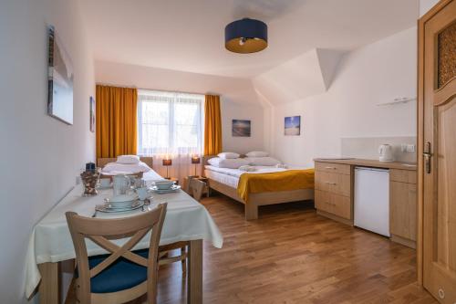 a room with a dining table and a bed at Willa Aga in Dębki