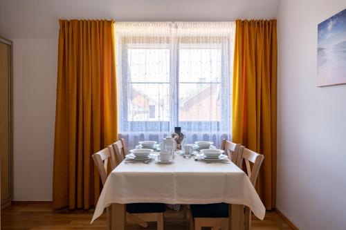a dining room table with a white table cloth on it at Willa Aga in Dębki