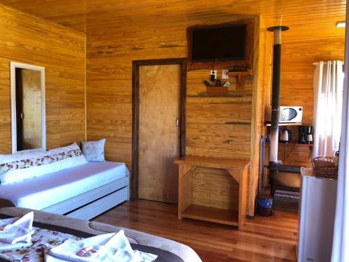 a bedroom with a bed and a flat screen tv at Hospedagem Família Cruz in Urubici