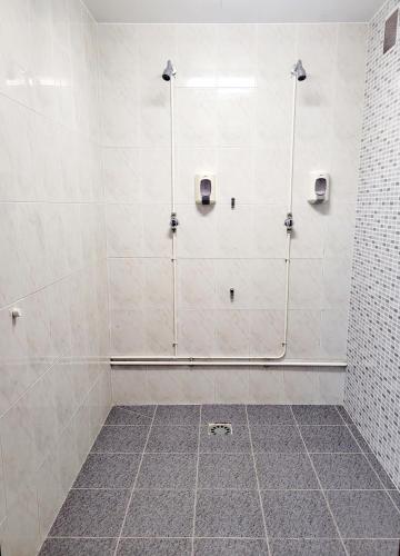a bathroom with a shower with white tiles at A CONDA-habitación privada in Arzúa