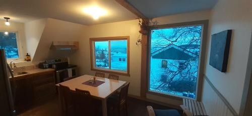 une petite cuisine avec une table et une fenêtre dans l'établissement Le Goéland, à Tadoussac