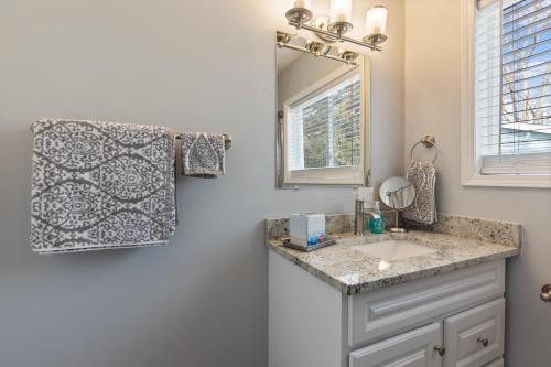 a bathroom with a sink and a mirror at Entire Home Near MSU and Local Hospitals with Fast Wi-Fi & Dedicated Office in Lansing