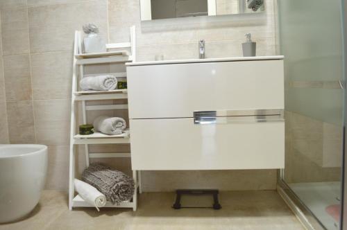 a bathroom with a sink and a mirror and towels at Málaga paraíso frente al mar in Málaga