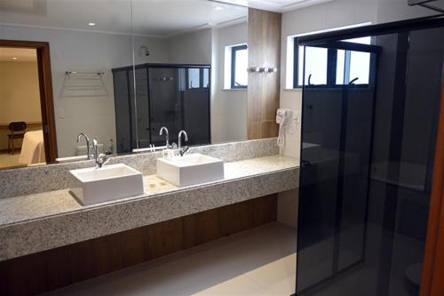 een badkamer met 2 wastafels en een grote spiegel bij Pituba Praiamar Hotel in Salvador